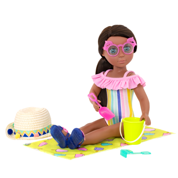 14-inch doll wearing rainbow swimsuit and sitting on beach towel