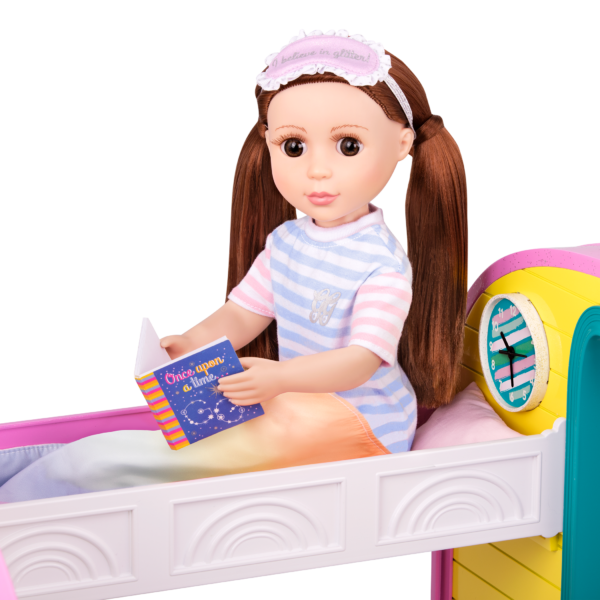 Doll sitting in bed reading storybook