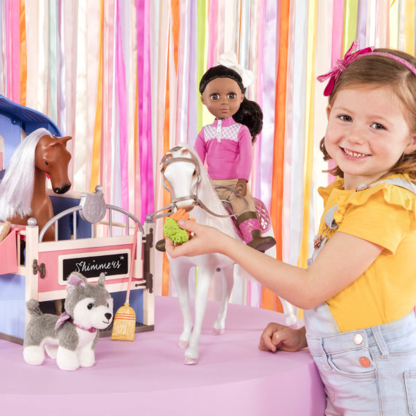 Kid playing with 14-inch doll wearing equestrian outfit on horse